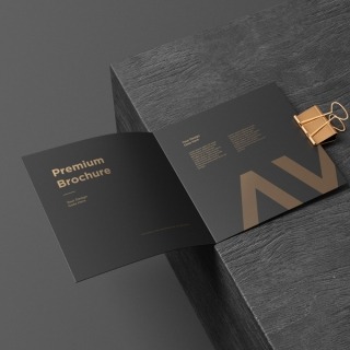 Open premium black brochure with gold typography placed on a dark textured surface — modern and minimalistic design